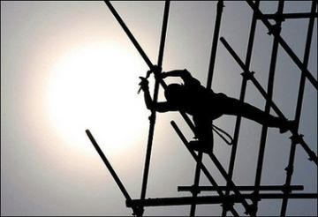 a chinese worker builds scaffolding for commercial